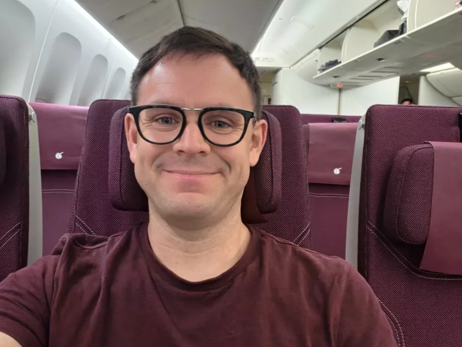 Ja v lietadle spoločnosti Qatar Airways (moje tričko ladí s farebnou schémou kabíny!)