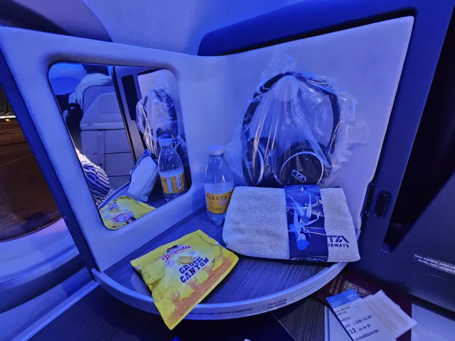 Otvárací panel so zrkadlom, slúchadlami, sušienkami a vodou